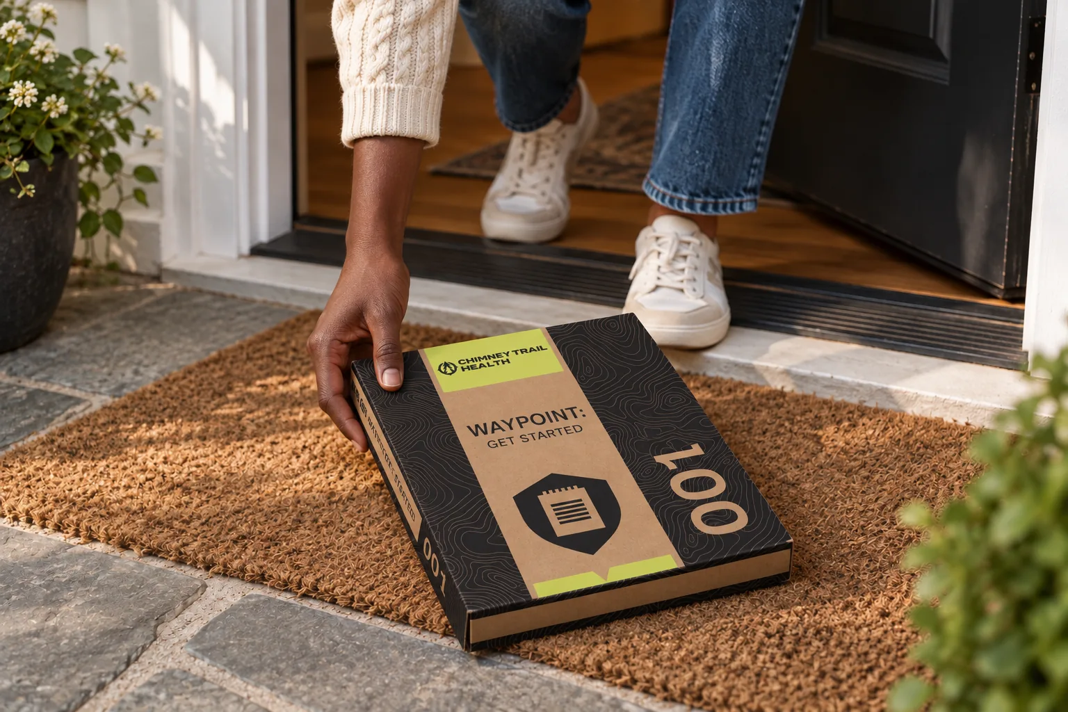 Person picking up a Waypoint 001 kit from their doormat